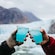Two people making a toast with iced beverages while standing near Stikine Icecap in Alaska